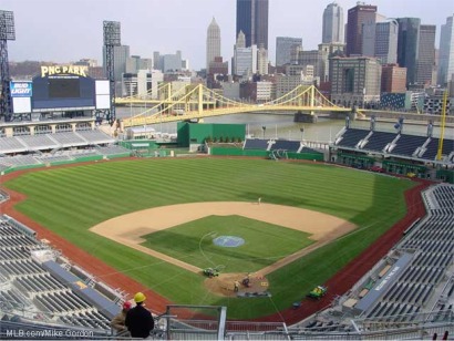 An empty PNC Park baseball stadium with a view of the Pittsburgh skyline in the background